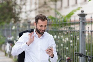 Smiling Handsome Man Using Phone While Walking